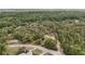 Aerial view of the densely wooded neighborhood with a road and some rooftops visible between the trees at 8310 Happy Trails, Kissimmee, FL 34747