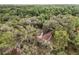 Aerial view shows a home nestled in a dense, tree-filled landscape, highlighting privacy and natural surroundings at 8310 Happy Trails, Kissimmee, FL 34747
