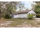 Exterior shot shows the home's white siding, dark roof, and well-maintained landscaping and foliage at 8310 Happy Trails, Kissimmee, FL 34747