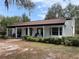 Charming exterior view of a single story home with columns, a front porch, mature landscaping, and a spacious front yard at 8310 Happy Trails, Kissimmee, FL 34747