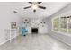 Bright living room featuring tile floors, fireplace, custom shelving, ceiling fan, bay window and a blue chair at 8310 Happy Trails, Kissimmee, FL 34747