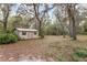 Small outbuilding on the property with a neutral color, simple design, and surrounded by lush trees at 8310 Happy Trails, Kissimmee, FL 34747
