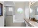 Bright bathroom featuring a tub with round window, and glass-door shower at 833 Brunello Dr, Davenport, FL 33897