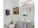 Powder room featuring a pedestal sink, toilet, and decorative mirror at 833 Brunello Dr, Davenport, FL 33897