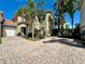 Stunning home showcasing a lushly landscaped yard, brick paved drive and a charming covered entry at 833 Brunello Dr, Davenport, FL 33897