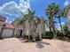 Charming two-story home with a tile roof, two-car garage, and lush tropical landscaping at 833 Brunello Dr, Davenport, FL 33897