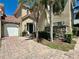 Beautiful home featuring a lushly landscaped yard, brick paved drive and a covered front entrance at 833 Brunello Dr, Davenport, FL 33897