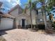 Charming two-story home with a tile roof, two-car garage, and lush tropical landscaping at 833 Brunello Dr, Davenport, FL 33897