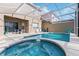 A screened-in pool area with lounge chairs, patio seating, and an in-ground hot tub at 833 Brunello Dr, Davenport, FL 33897
