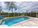 Screened-in pool area featuring an in-ground pool and hot tub with outdoor seating and palm trees at 833 Brunello Dr, Davenport, FL 33897