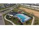 Community pool from above, with a play area, palm trees and an empty field nearby in the neighborhood at 895 Overpool Ave, Davenport, FL 33896