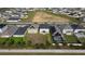 Birds eye view of houses in a suburban neighborhood with open fields, lawns, and community pool nearby at 895 Overpool Ave, Davenport, FL 33896