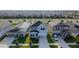 Birds eye view of a two-story house with a driveway in a suburban neighborhood with similar houses at 895 Overpool Ave, Davenport, FL 33896