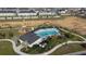Aerial view of a community pool with a play area and palm trees with an empty field nearby at 895 Overpool Ave, Davenport, FL 33896