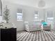 Well-lit Bedroom showcasing a crib, comfortable chair, and large windows offering ample natural light at 895 Overpool Ave, Davenport, FL 33896