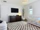 Stylish Bedroom complete with a dark wood dresser, changing station, a TV, and decorative plant at 895 Overpool Ave, Davenport, FL 33896