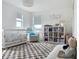 Bright Bedroom featuring a crib, cozy chair, and full bookshelf, creating a nurturing and organized space at 895 Overpool Ave, Davenport, FL 33896
