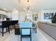 Stylish dining room with modern light fixture, seating for six, and open to living area at 895 Overpool Ave, Davenport, FL 33896