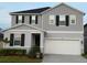 Charming two-story home featuring gray siding, black shutters, and a well-manicured front yard at 895 Overpool Ave, Davenport, FL 33896