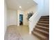 Inviting foyer with tiled floors, staircase, and view into a bedroom at 895 Overpool Ave, Davenport, FL 33896