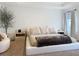 Bright main bedroom featuring neutral tones, an accent chair, and bedside tables at 895 Overpool Ave, Davenport, FL 33896