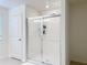 Modern bathroom featuring a sleek glass-enclosed shower with white subway tile and contemporary fixtures at 895 Overpool Ave, Davenport, FL 33896