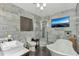 Bright bathroom featuring marble walls, modern fixtures, and a separate glass shower at 955 Mansfield Rd, Tavares, FL 32778