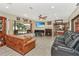 Inviting living area with a fireplace, ceiling fan, large windows overlooking a serene outdoor view, and plush seating at 955 Mansfield Rd, Tavares, FL 32778
