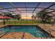 Beautiful pool overlooking a sunset view, enclosed with a screen and surrounded by brick pavers at 955 Mansfield Rd, Tavares, FL 32778