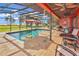 Screened-in pool area with lounge chairs, tables, and views of the surrounding landscape at 955 Mansfield Rd, Tavares, FL 32778