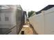 View down the side of the house between a screened-in patio and a white fence at 1025 Belvoir Dr, Kissimmee, FL 34744