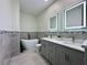 Modern bathroom featuring a soaking tub, illuminated mirrors, double vanity, and contemporary tile work at 1025 Belvoir Dr, Kissimmee, FL 34744