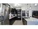 Modern kitchen featuring stainless steel appliances, black cabinets, and a spacious white quartz countertop at 1025 Belvoir Dr, Kissimmee, FL 34744