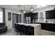 Sleek kitchen featuring black cabinetry, stainless steel appliances, a spacious island, and pendant lights, ideal for modern cooking at 1025 Belvoir Dr, Kissimmee, FL 34744