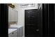 A tidy laundry room with a black door, overhead cabinets, and a modern washer and dryer at 1025 Belvoir Dr, Kissimmee, FL 34744