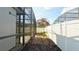 View of the backyard pool surrounded by screens, landscaping, and a white fence under a bright blue sky at 1025 Belvoir Dr, Kissimmee, FL 34744