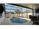 Exterior view of the beautiful blue in ground pool with seating nearby, within a screened patio at 1025 Belvoir Dr, Kissimmee, FL 34744