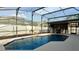 Beautiful in ground swimming pool with outdoor lighting and a screened-in enclosure at 1025 Belvoir Dr, Kissimmee, FL 34744