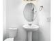 Bright, simple bathroom with pedestal sink, toilet and oval mirror at 11037 Bagley Aly, Windermere, FL 34786