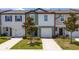 Exterior view of a charming townhome with an attached garage and landscaped yard at 1113 Merrill St, Davenport, FL 33837