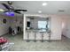 Open kitchen bar with seating, granite countertop, track lighting, and open view to the dining room at 1126 Orwell Ave, Orlando, FL 32809