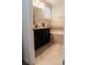 Bathroom featuring tile flooring, black vanity with sink, and tiled tub with grey mosaic accents at 11378 Whistling Pine Way, Orlando, FL 32832