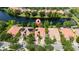 Aerial view of waterfront homes with terracotta roofs surrounded by trees and lush landscaping at 12041 Kajetan Ln, Orlando, FL 32827