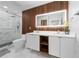 This luxury bathroom features double sinks, wood accents, and a glass enclosed shower at 12041 Kajetan Ln, Orlando, FL 32827
