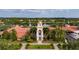 Aerial shot of clubhouse with clock tower, beautiful landscaping, and serene waterfront views at 12041 Kajetan Ln, Orlando, FL 32827