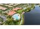 Aerial view featuring a community clubhouse, pool, tennis courts, and lakeside scenery at 12041 Kajetan Ln, Orlando, FL 32827
