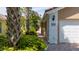 The house number stands out next to the garage and the red brick driveway in a lush tropical environment at 12041 Kajetan Ln, Orlando, FL 32827