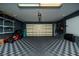 A spacious garage features checkered floors and storage for bicycles, shelving, and a go-kart at 12041 Kajetan Ln, Orlando, FL 32827