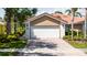 Features a two-car garage, red brick driveway, well-manicured lawn, and beautiful landscaping at 12041 Kajetan Ln, Orlando, FL 32827