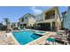 Large swimming pool and spa with a basketball hoop, chairs, and manicured hedges in the backyard at 1228 Castle Pines Ct, Reunion, FL 34747